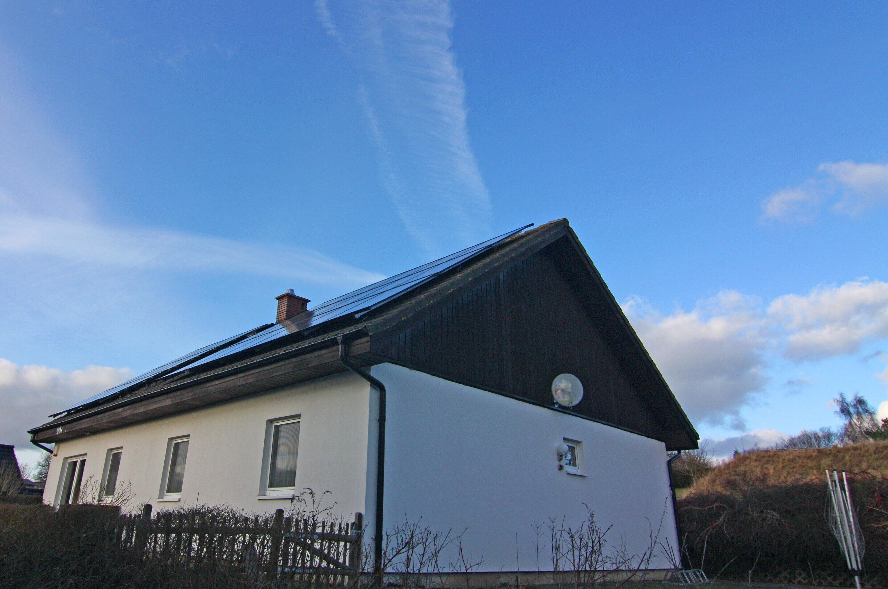 Une maison à deux étages, dotée d’un toit en pente et d’une antenne parabolique.