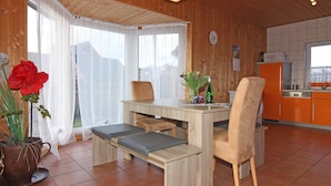 Una cocina moderna con armarios de madera y una zona de comedor con banco.