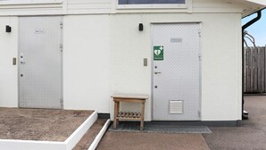 A building with two doors, one labeled 'Disk & Tvatt' and another with a green sign indicating a first aid station. - 4 Person Holiday Home in Falkenberg (Falkenberg)