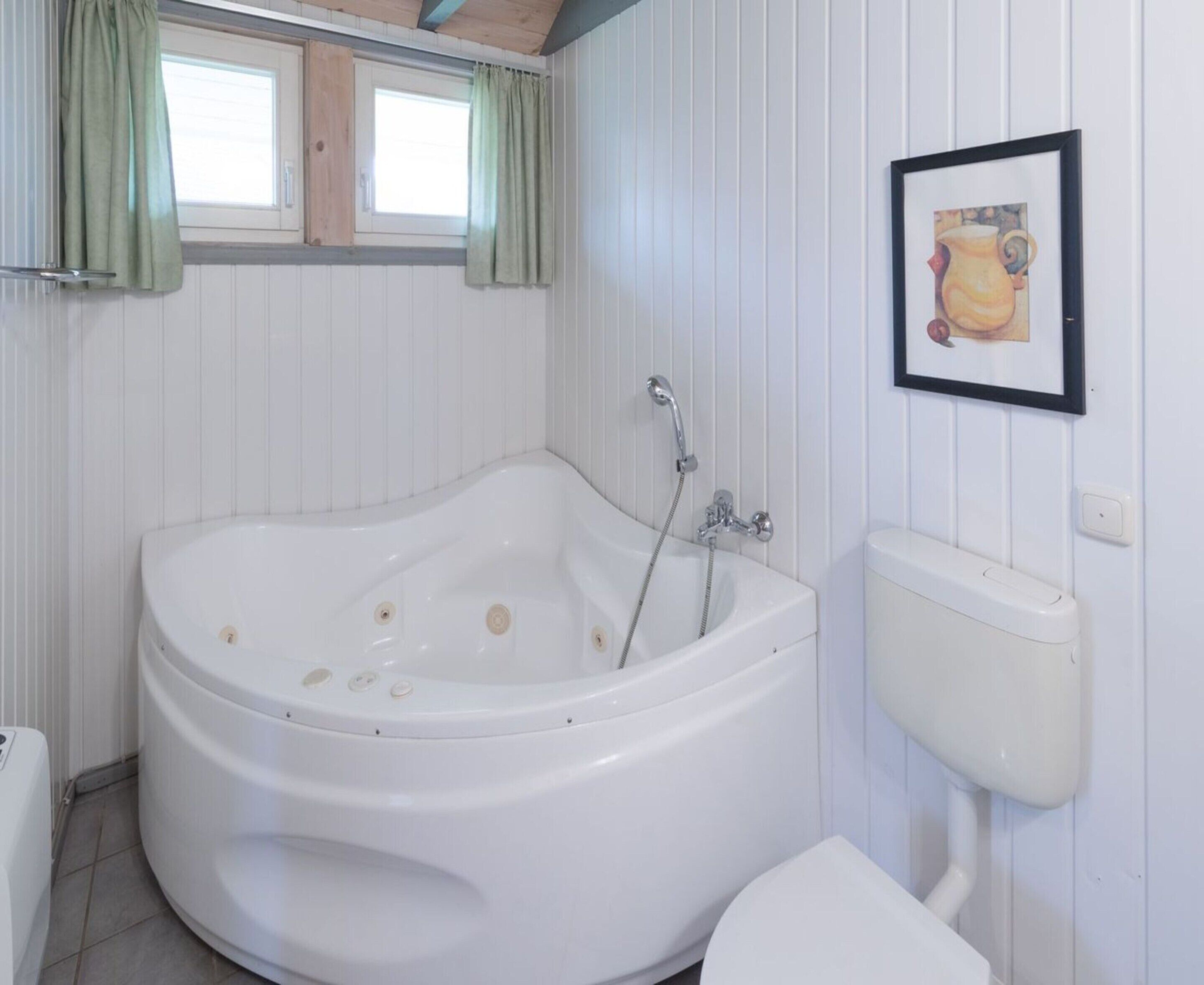 Ein Badezimmer mit einer großen Badewanne, einer Toilette und einem Waschbecken.
