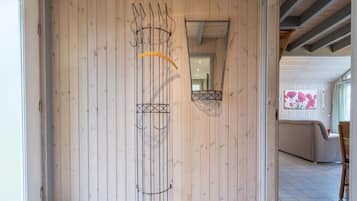 Un interior de madera con diseño moderno, que incluye una obra de arte única y un acceso visible a otra habitación.