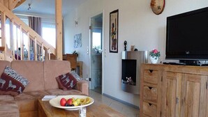 A living room with a wooden coffee table, a sofa, a television, and a cabinet. - Charmante Ferienwohnung (Rechlin)