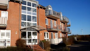 A multi-story residential building with a brick facade, large windows, and balconies. - 4 Star Holiday Home in Neuschonberg (Schönberg)