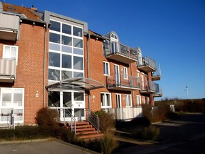 A multi-story residential building with a brick facade, large windows, and balconies. - 4 Star Holiday Home in Neuschonberg (Schönberg)