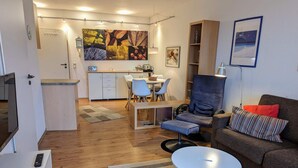 A modern living room with a sofa, a dining area, and a kitchen. - 4 Star Holiday Home in Neuschonberg (Schönberg)