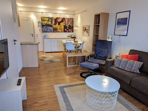 A modern living room with a sofa, a dining area, and a kitchen. - 4 Star Holiday Home in Neuschonberg (Schönberg)