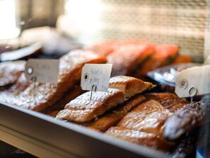 Una exhibición de diferentes tipos de pescado, incluyendo Hellefisk, con etiquetas de precio.