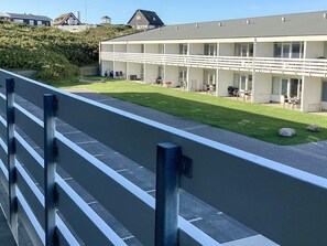 A modern building with a flat roof, multiple windows, and a well-maintained lawn. - 4 Star Holiday Home in Ringkobing (Ringkobing)