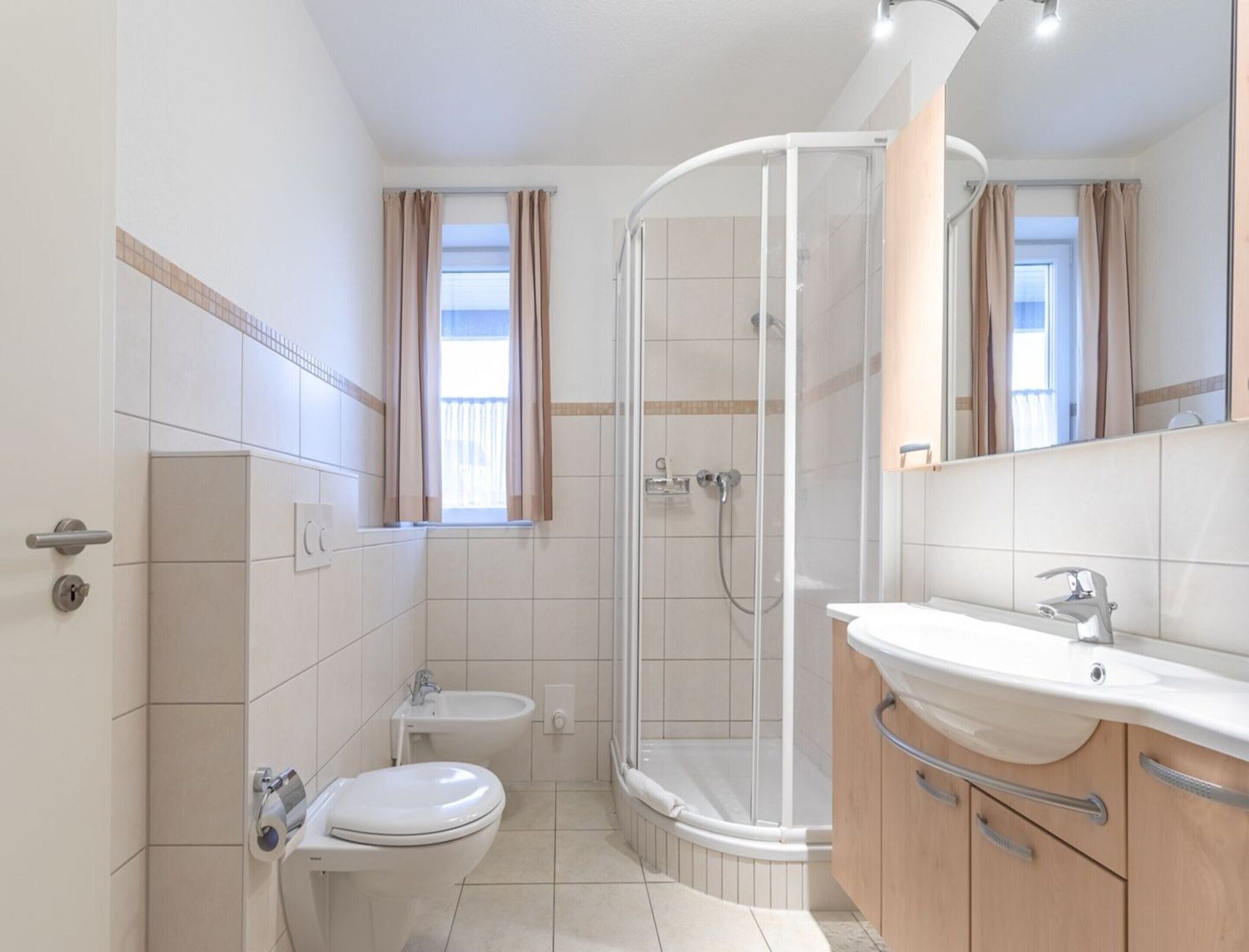 Un baño moderno con inodoro, bidé y ducha.