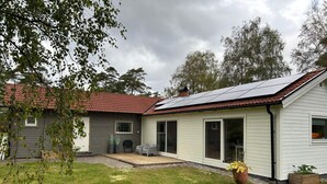 A two-story house with a red-tiled roof, a covered patio, and a solar panel installation. - 4 Star Holiday Home in Mellbystrand (Mellbystrand)