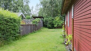 A red building with a wooden fence and a grassy yard. - 4 Star Holiday Home in Mellbystrand (Mellbystrand)