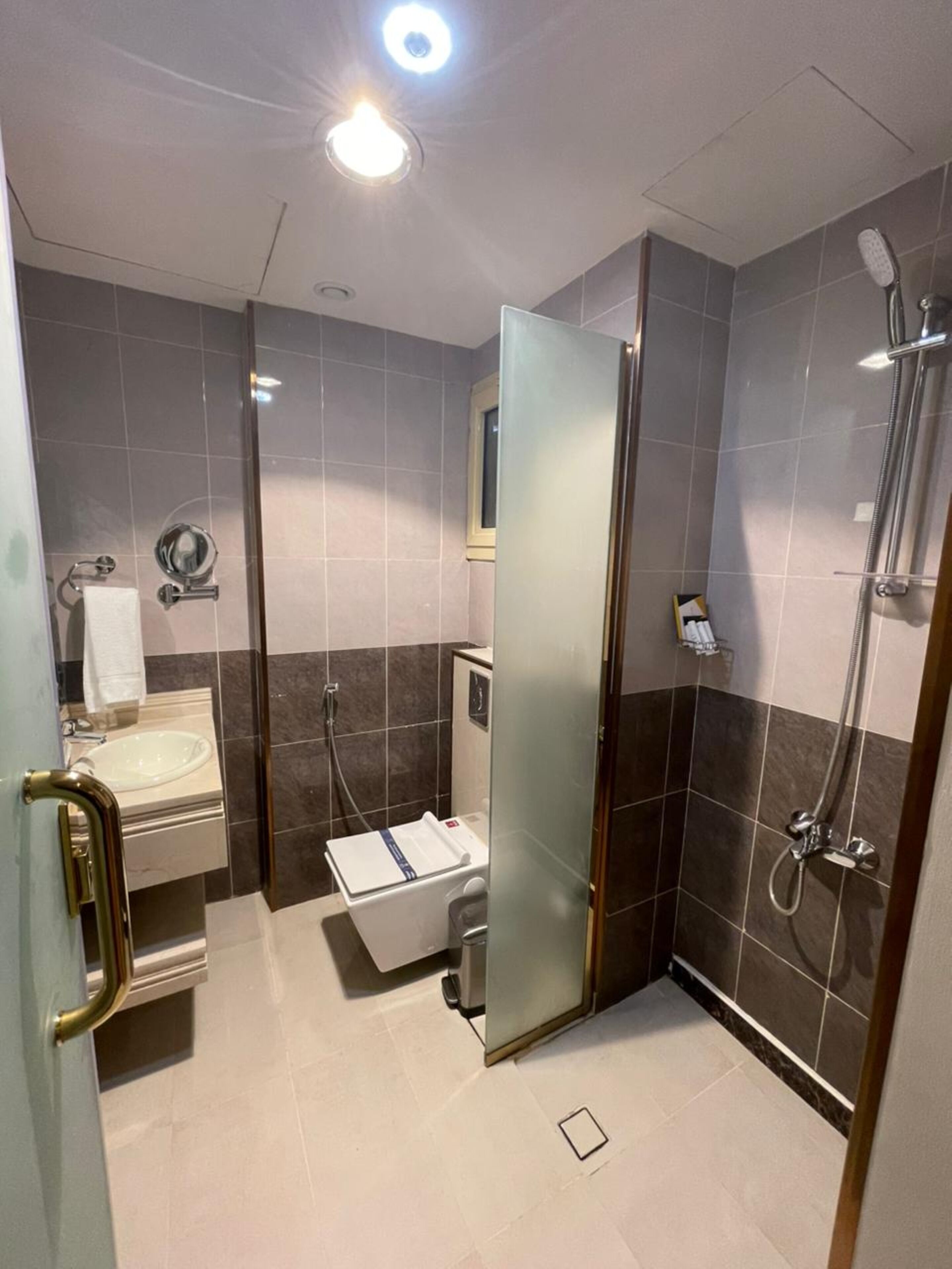 Ein modernes Badezimmer mit Duschkabine aus Glas, Waschbecken und Toilette.