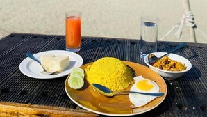 Een maaltijd aan tafel met uitzicht op het strand en de oceaan.