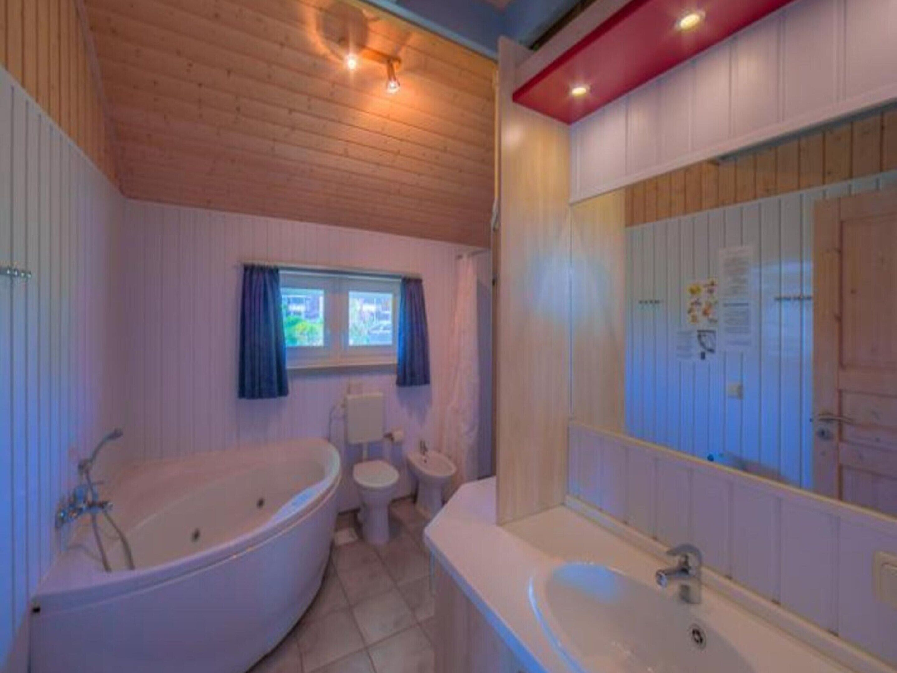 Un baño con bañera, inodoro y lavamanos.