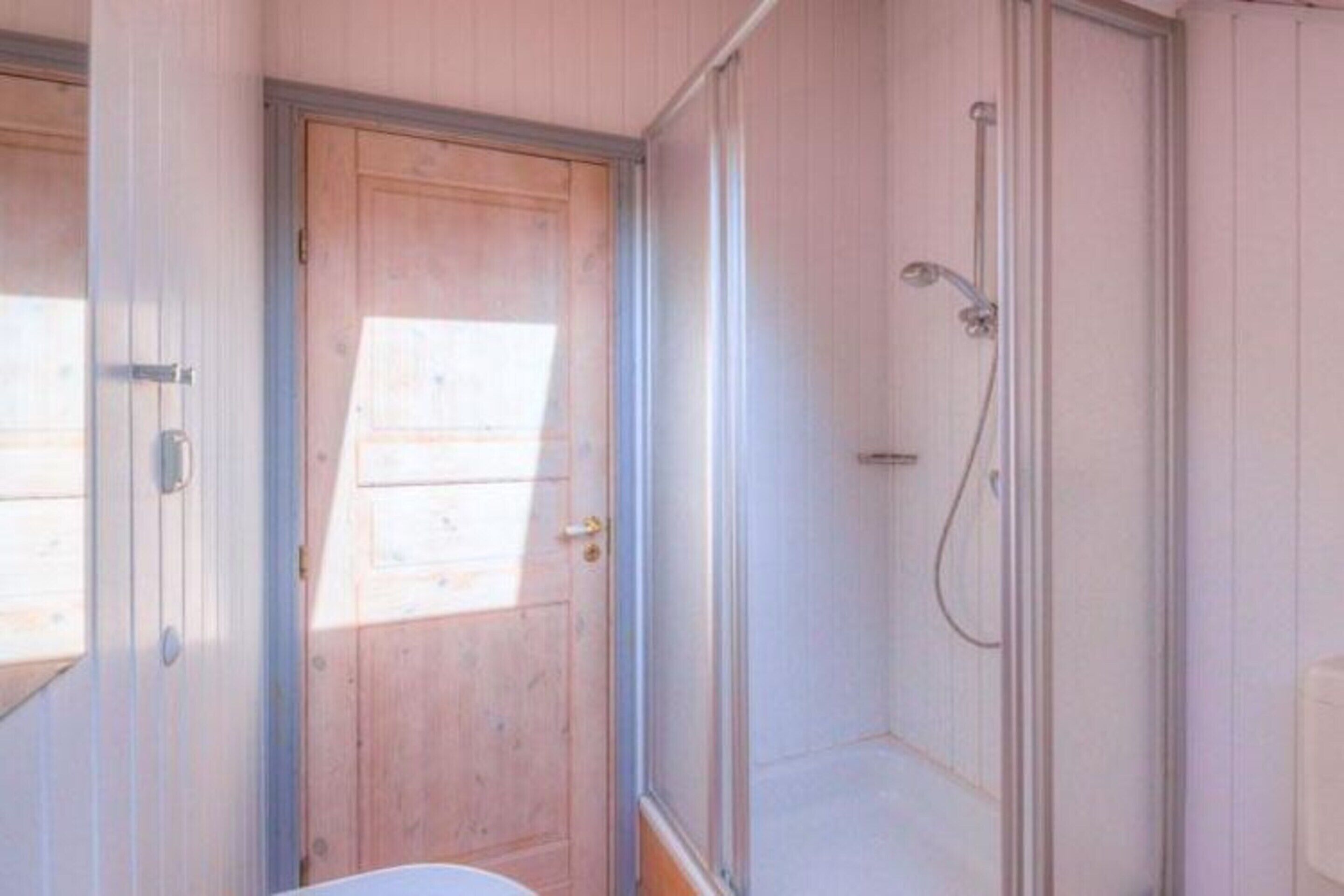 A bathroom with a shower, a toilet, and a sink.
