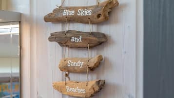 A wooden sign with the words "Blue Skies and Sandy Beaches" hung on a wall.