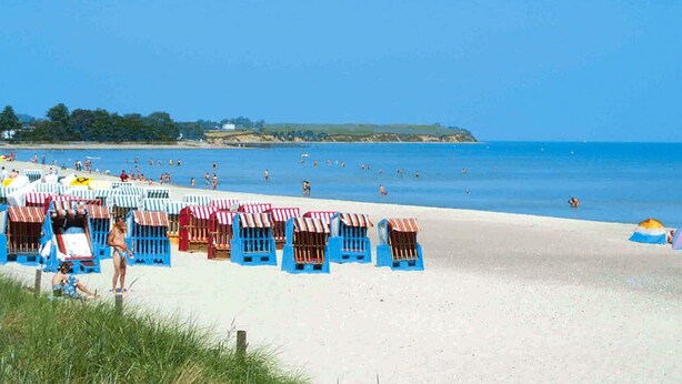 A beach with rows of blue beach huts and a sandy shore. - Doppelhaushalften Boltenhagen in Deutschland (Boltenhagen)