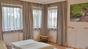 A bedroom with a bed, a chair, a radiator, and a painting on the wall. - Chalet in Fulpmes Near Stubai Glacier Skiing (Fulpmes)