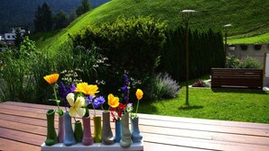 A wooden table with colorful vases of flowers. - Chalet in Fulpmes Near Stubai Glacier Skiing (Fulpmes)