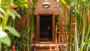 A wooden building with a wooden staircase leading to a door. - Lumeria Yoga (Ubud)