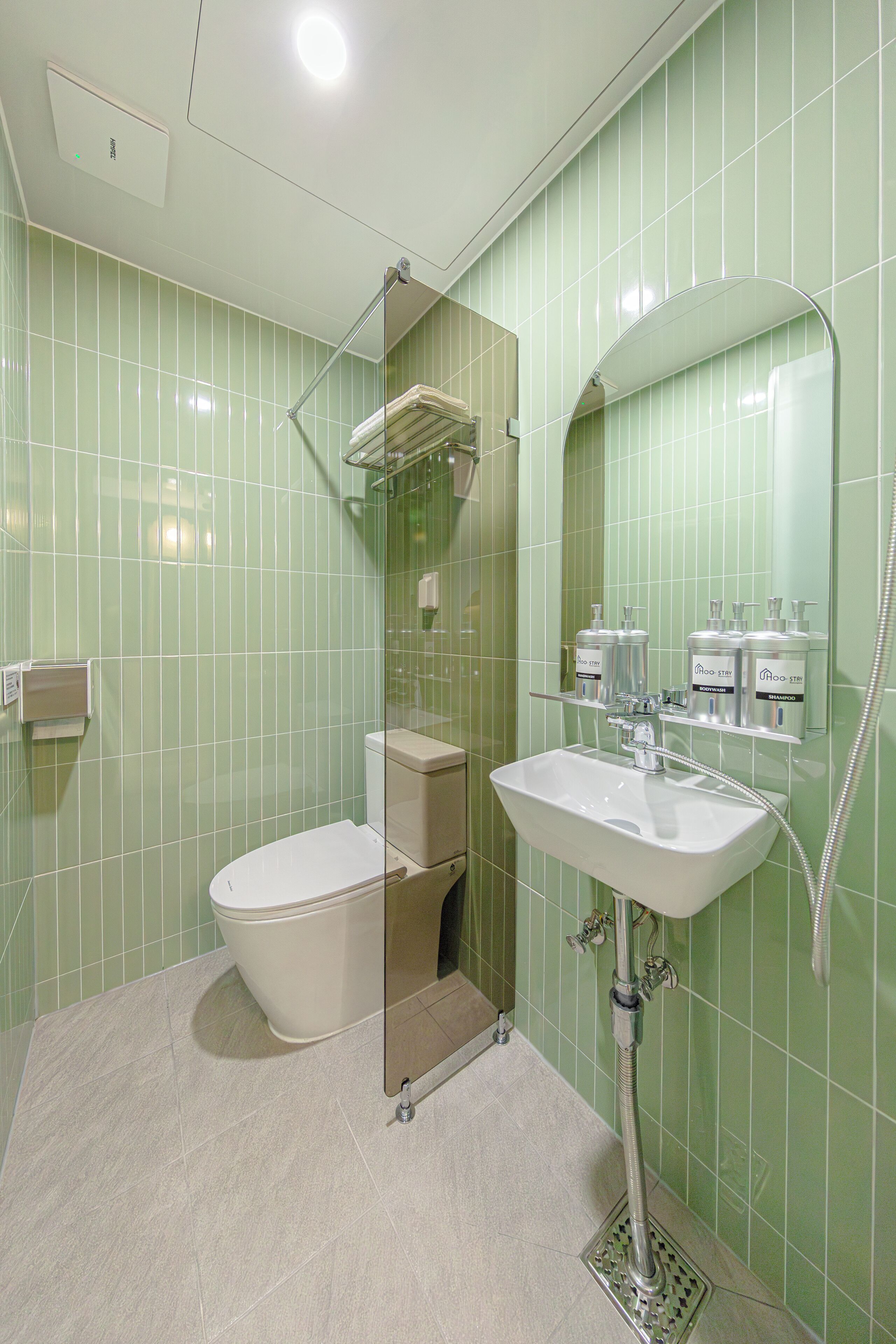 Une salle de bain avec des toilettes, un lavabo et une douche.