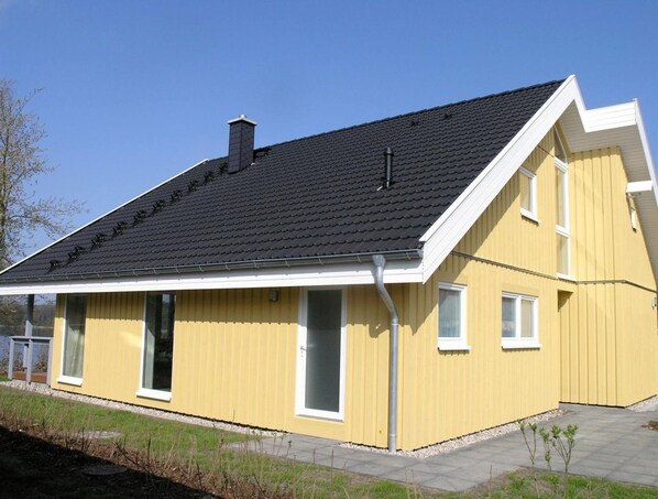 A yellow building with a black roof, white trim, and a single visible window. - Skandinavisches Ferienhaus in Mirow (Mirow)