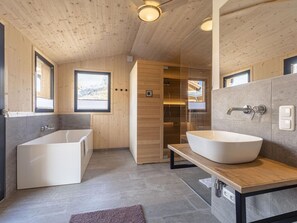 A modern bathroom with a freestanding bathtub, a large sink, and a sauna. - Attractive Chalet With Terrace (Sankt Georgen am Kreischberg)