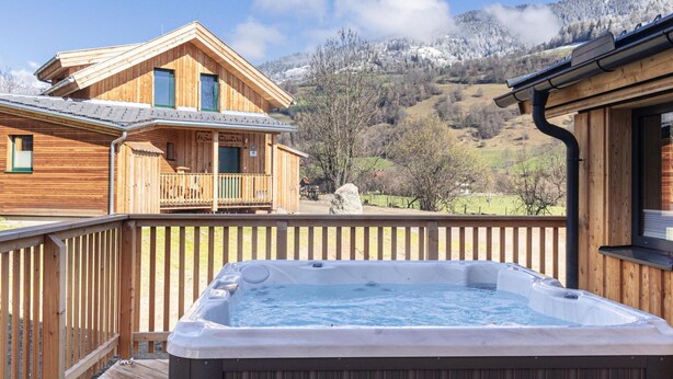 A wooden cabin with a hot tub and a mountain view. - Attractive Chalet With Terrace (Sankt Georgen am Kreischberg)