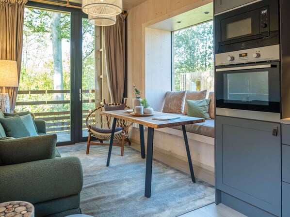 Una sala acogedora con un sofá, una mesa de comedor y una cocina con horno.