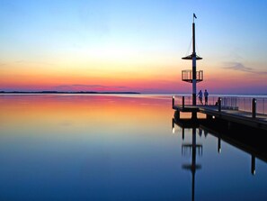 Enjoy serene waterfront views from the pier, where a flagpole stands tall.