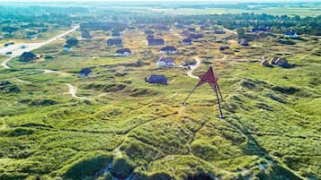 A rural landscape with scattered houses and a prominent red star-shaped structure.