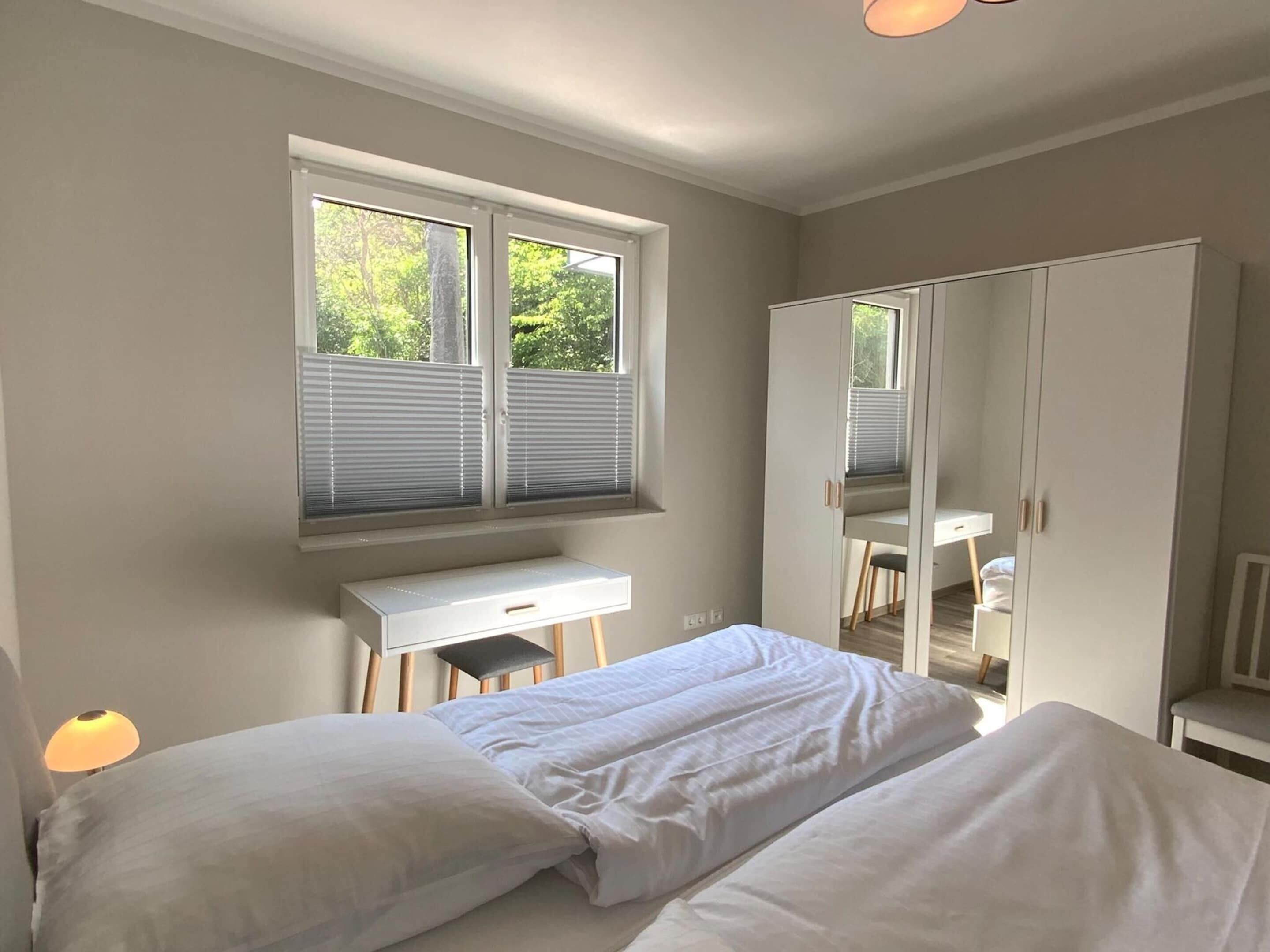 Ein Schlafzimmer mit Bett, Schreibtisch und Kleiderschrank.