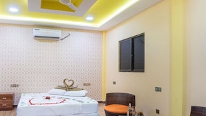 A bedroom with a bed, a ceiling fan, a window, and a table with chairs. - NikainnHimandhoo (Himandhoo)