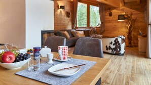 A cozy cabin interior with a dining table set for breakfast, a sofa, and a rustic decor. - Chalet in Leutasch Near Ski Trails (Leutasch)
