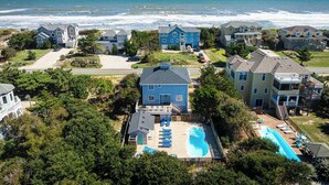 A residential area with houses, a swimming pool, and a view of the ocean.