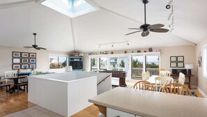 A spacious kitchen with a central island, a dining area, and a view of the outdoors.