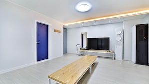 Un salon moderne avec un banc en bois, un téléviseur à écran plat et un banc intégré doté d’un miroir.