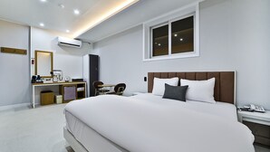 A modern hotel room with a large bed, a desk with a chair, a small table, and a window. - Gimcheon Sweet Hotel (Gimcheon)