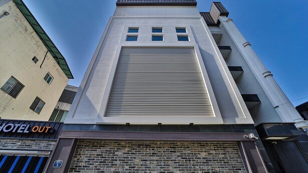 A building with a sign reading "SWEET HOTEL" and a closed shuttered entrance. - Gimcheon Sweet Hotel (Gimcheon)