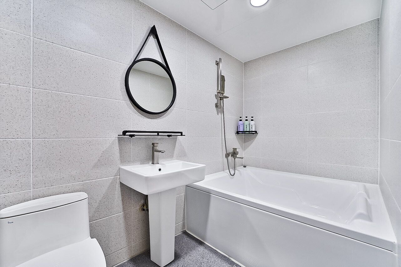 A modern bathroom with a toilet, sink, and bathtub.