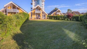 A modern hotel with a central tower, multiple balconies, and a well-maintained lawn. - Exclusive Skandinavisches, Rechlin (Rechlin)