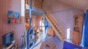 A wooden interior with a TV, fireplace, sofa, and staircase. - Exclusive Skandinavisches, Rechlin (Rechlin)