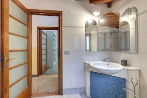 A bathroom with a sink, mirror, and tiled walls. - Faenza 64 in Firenze (Florence)
