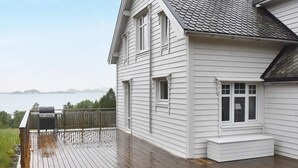 Una casa bianca con un molo di legno e vista sull'acqua.