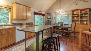 A spacious kitchen with wooden cabinets, a central island, and a dining area with wooden tables and chairs. - Summer special, stay before 9/8/26 get third night free. (Welches)