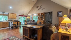 A spacious living area with a high ceiling, wooden furniture, and a stone fireplace. - Summer special, stay before 9/8/26 get third night free. (Welches)