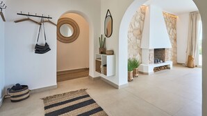 A spacious living area with a fireplace, a coat rack, and a hanging bag. - Lago Spectacular Villa on the Seafront (Cala D'or)