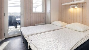 A bedroom with a bed, a wardrobe, a window, and a balcony. - Peaceful Cabin in Camping Resort (Lokken)