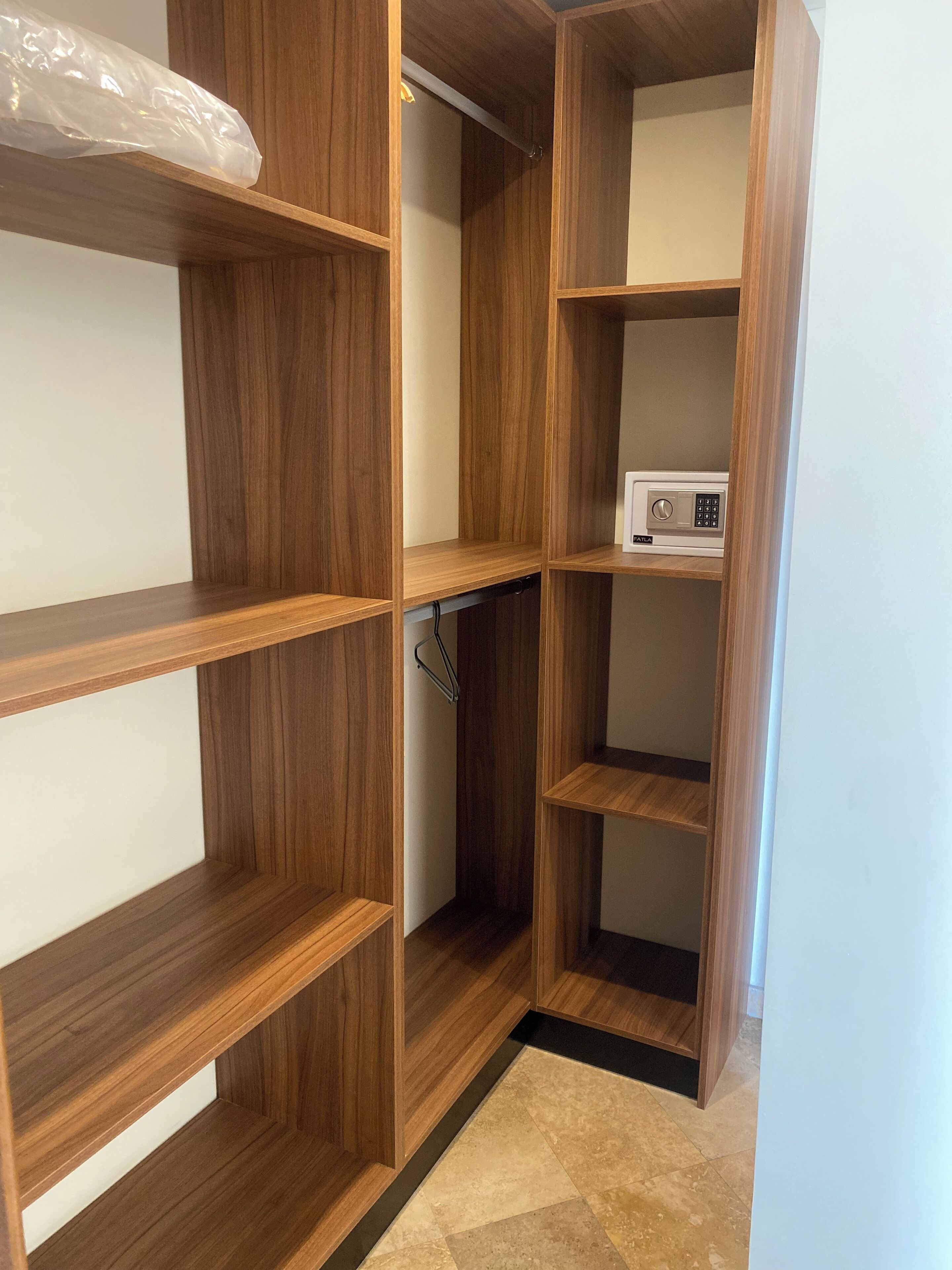 A wooden closet with multiple shelves and a built-in appliance.