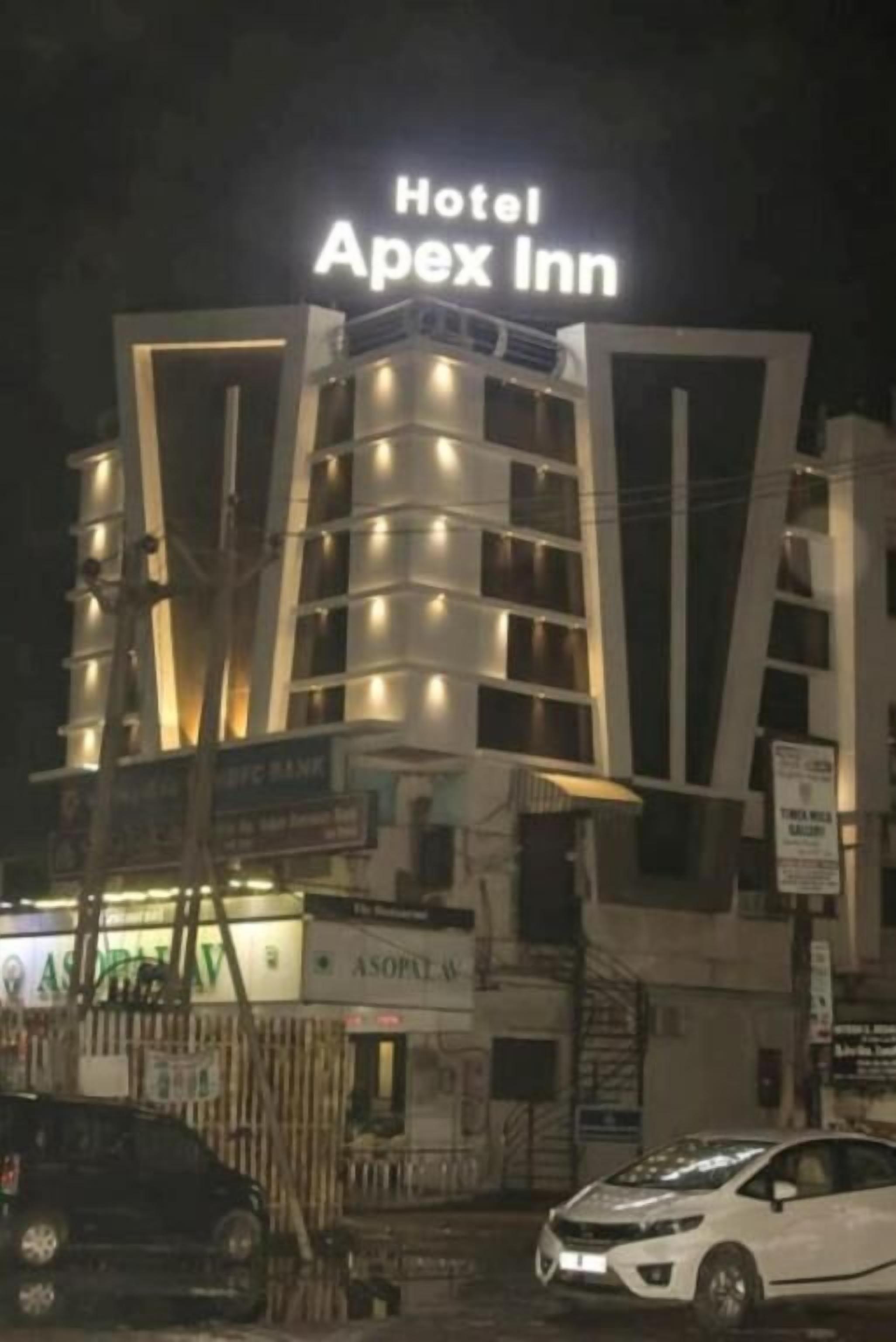 Een meerhoog gebouw met het bord "Hotel Apex Inn" bovenaan.